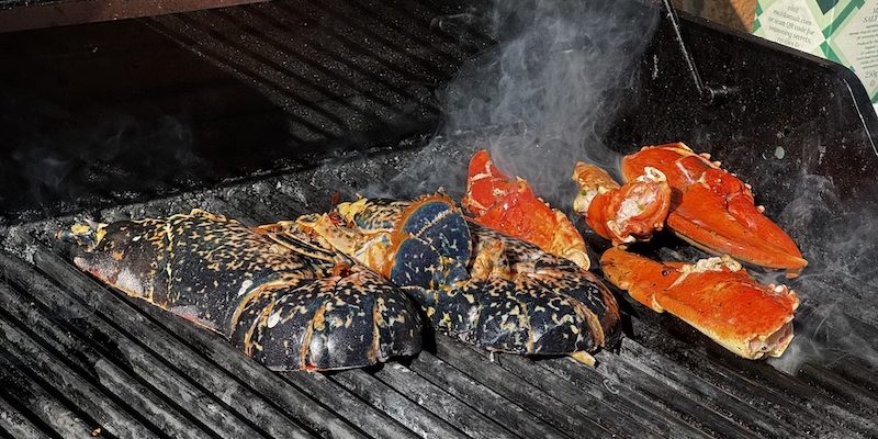 Grilled lobster split and basted with Mediterranean butter on plate